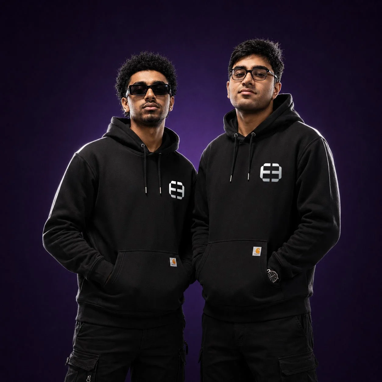 Two people wearing black E3 Group hoodies
