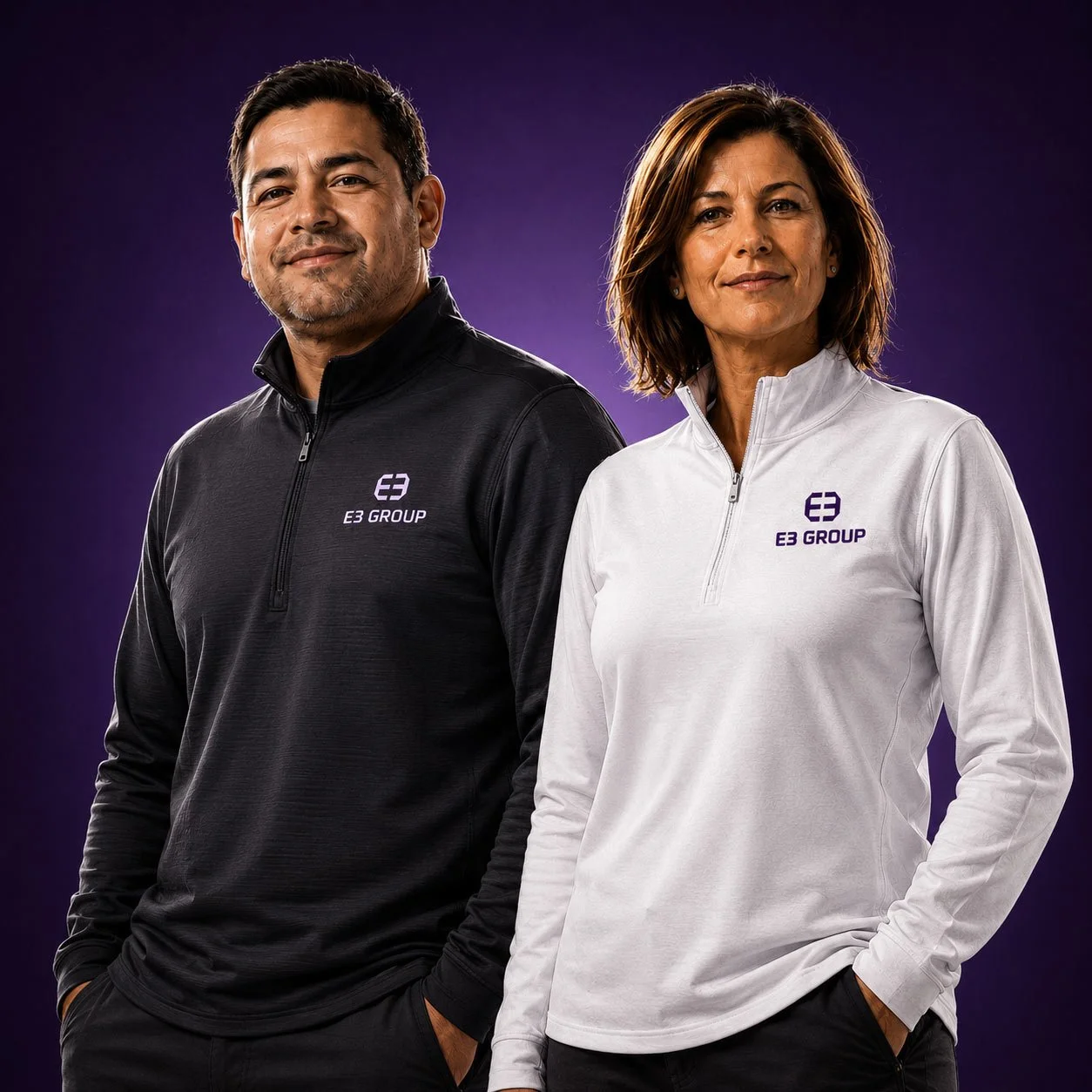 Two people in E3 Group quarter zips, one black and one white