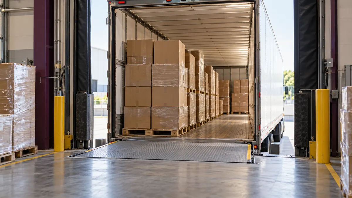 An open trailer at a loading dock, stacked with boxed freight